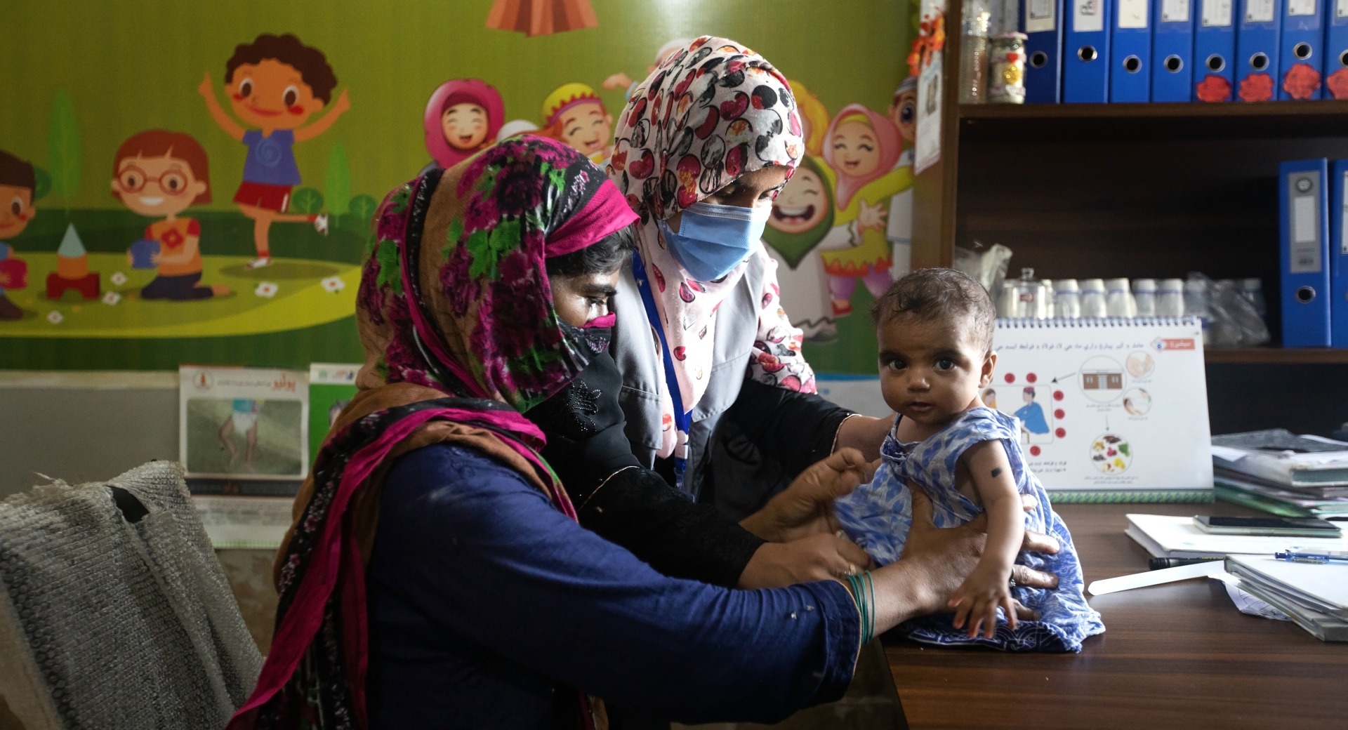 Dr. Zarina Lashari, a nutrition assistant, consults with a mother and child at an outpatient treatment center in Sindh, Pakistan.