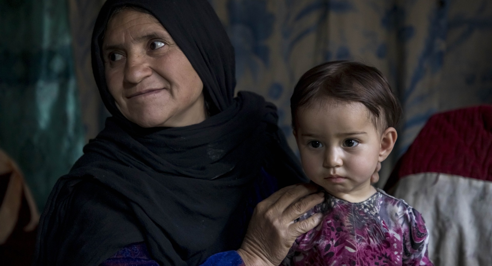 Mahnaz holds her youngest daughter, 13-month-old Maimana, in their home in Duykondi Province, Afghanistan. Action Against Hunger works in this area to manage feeding programs and provide mobile health and nutrition support.